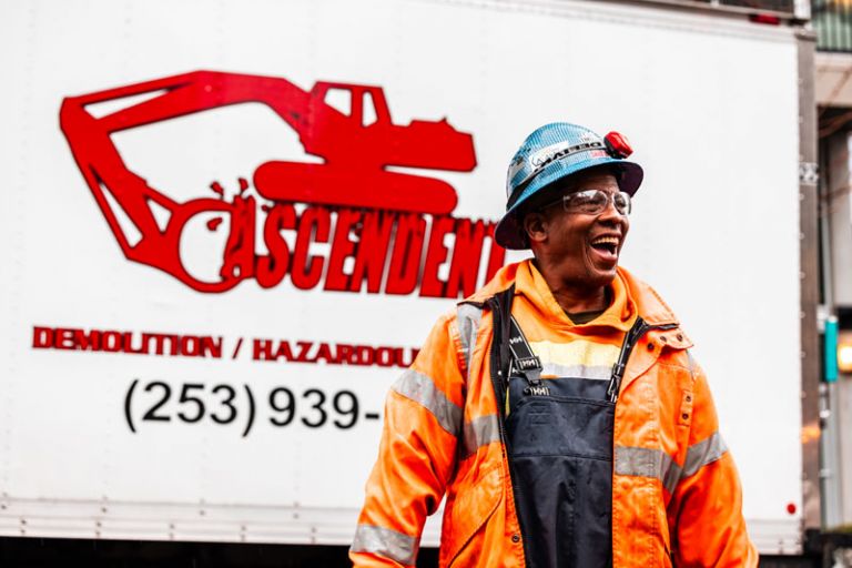A photo of an employee smiling with a hard hat and work gear on. Careers at Ascendent Demolition | Seattle, WA